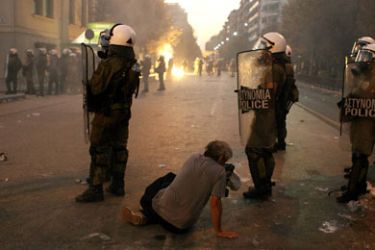 r_ protester sits in front of riot police guarding the entrance to Thessaloniki's International Trade Fair during a protest against austerity September 10, 2011