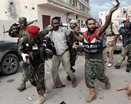 الثوار يعتقلون أحد عناصر كتائب القذافي في سرت (رويترز)
