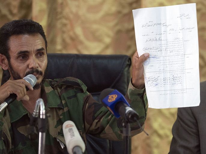 GUE306 - Zintan, -, LIBYAN ARAB JAMAHIRIYA : Ajmi al-Atiri, commander of the Zintan brigade that arrestedf Seif al-Islam, the detained son of slain leader Moamer Kadhafi, shows a document during a press conference in the Libyan city of Zintan on June 9, 2012.
