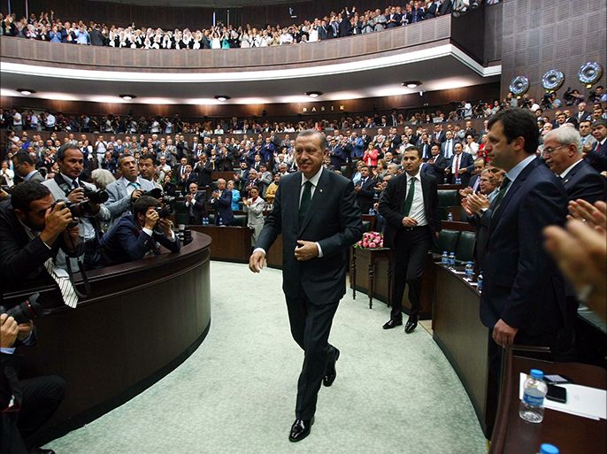Turkish Prime Minister Recep Tayyip Erdogan is applauded by members of parliament from his ruling Justice and Development Party (AKP) during a meeting at the Turkish parliament in Ankara on June 25, 2013. Erdogan yesterday praised the police "heroism" in handling several weeks of unrest that threw up the biggest challenge yet to his government after more than a decade in power. AFP PHOTO/ADEM ALTAN