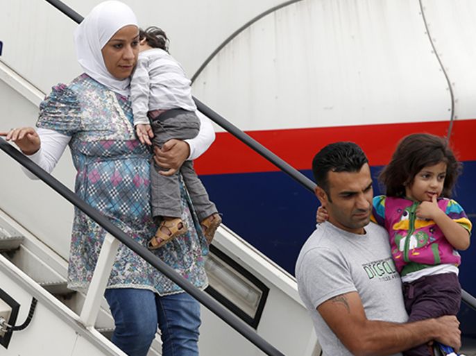 Members of a group of 101 refugees from Syria, leave an airplane at the airport in Hannover, Germany, Wednesday, Sept. 11, 2013. The refugees are the first of up to 5,000 who will come to Germany.