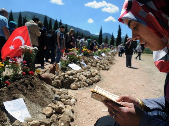 Family members pray at the cemetery in the coal miners' town of Soma, Turkey, Sunday, May 18, 2014. Eighteen people, including mining company executives, have been detained as Turkish officials investigate the mining disaster that killed 301 people, a domestic news agency reported Sunday. (AP Photo/Emre Tazegul)