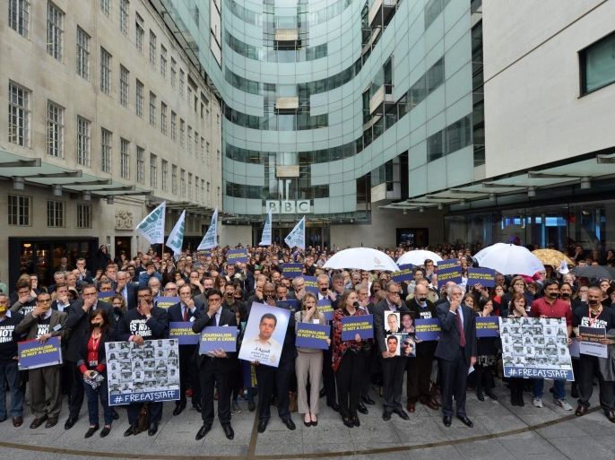 A handout photo dated 07 April 2014 showing a protest in London, Britain, by BBC journalists in support of Aljazeera staff held under captivity in Egypt. BBC journalists gathered for a one minute silence with their mouths covered. EPA/JEFF OVERS / HANDOUT