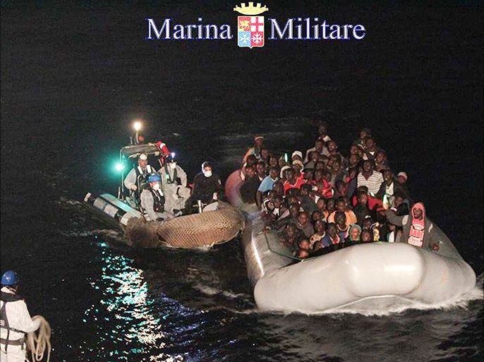 Migrants sit in their boat during a rescue operation by Italian navy ship Scirocco about 40 nautical miles off the coast of Libya in this handout picture released on June 14, 2014 by the Italian Marina Militare. Ten migrants drowned after the boat they were travelling in sank off the Libyan coast, Italy's navy said on Saturday, reporting the latest deaths among thousands of migrants trying to reach Europe from Africa and Syria. At least 50,000 people have crossed from North Africa to Italy so far this year, exceeding the 40,000 who arrived in the whole of 2013, according to the Italian coastguard authorities. REUTERS/Marina Militare/Handout via Reuters (MID SEA - Tags: SOCIETY IMMIGRATION MARITIME DISASTER)