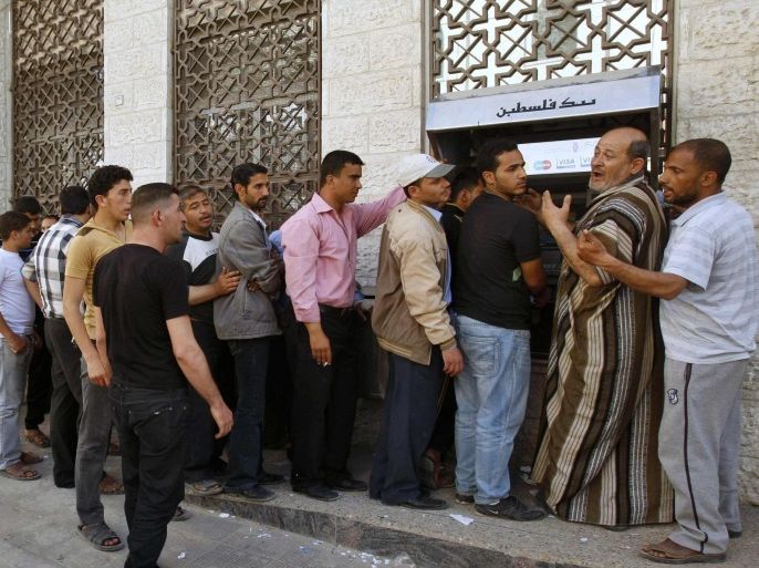 Palestinian Authority (PA) employees queue to receive their salaries from an ATM in Khan Younis in the southern Gaza Strip April 10, 2012. Paying the upkeep of its worst political rival and getting little in return is taking its toll on the deficit-racked Palestinian Authority. The Western-backed PA, many of whose top leaders belong to the mainstream Fatah movement, says it has poured around $7 billion into the Gaza Strip since its rival Hamas seized control in 2007, but complains that the Islamist group is stymieing its efforts to balance its books. Picture taken April 10, 2012. To match Feature PALESTINIANS-HAMAS/FINANCES REUTERS/ Ibraheem Abu Mustafa (GAZA - Tags: BUSINESS POLITICS)