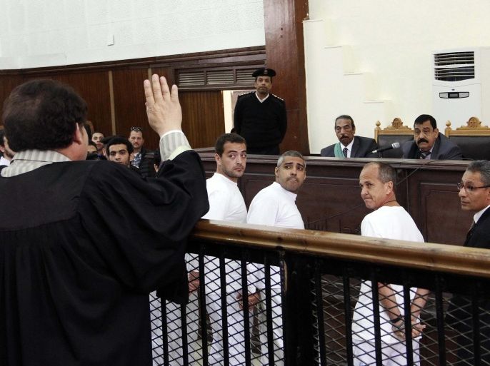 FILE- In this Monday, March 31, 2014 file photo, Al-Jazeera English producer Baher Mohamed, center left, Canadian-Egyptian acting Cairo bureau chief Mohammed Fahmy, center, and correspondent Peter Greste, second right, appear in court along with several other defendants during their trial on terror charges, in Cairo, Egypt. Judge Mohammed Nagui Shehata sentenced the three journalists to seven years in prison. They had been accused of supporting the Muslim Brotherhood, which the authorities have declared a terrorist organization. The case has caused an outcry, with rights groups saying the prosecution of the journalists was politicized and undermines freedom of expression in Egypt. (AP Photo/Heba Elkholy, El Shorouk, File) EGYPT OUT