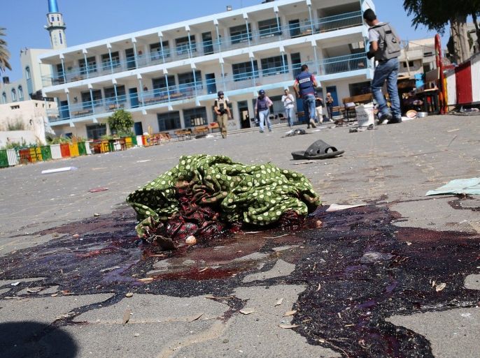 A piece of cloth lies in a pool of blood outside a UN-operated school after an Israeli attack in Beit Hanun town, northern Gaza strip, 24 July 2014. At least 16 Palestinians were killed, among them seven children, and some 200 injured when an UN-operated school north of Gaza City was struck by Israeli tank shells, the Gaza Health Ministry said. Witnesses, who were in the school run by the United Nations for Relief and Work Agency (UNRWA), said Israeli tanks fired four shells at the school.