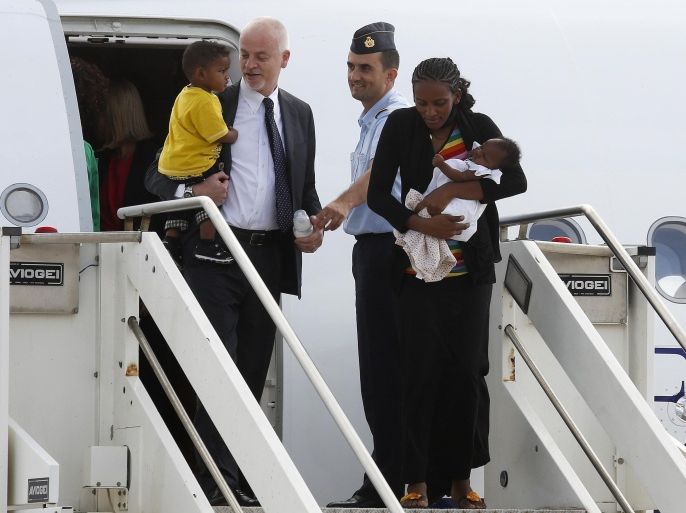 Mariam Yahya Ibrahim of Sudan (R) holds one of her children next to Lapo Pistelli (L), Italy's vice minister for foreign affairs, holding her other child, as they land at Ciampino airport in Rome July 24, 2014. The Sudanese woman who was spared a death sentence for converting from Islam to Christianity and then barred from leaving Sudan flew into Rome on Thursday. REUTERS/Remo Casilli (ITALY - Tags: RELIGION POLITICS CRIME LAW TPX IMAGES OF THE DAY)