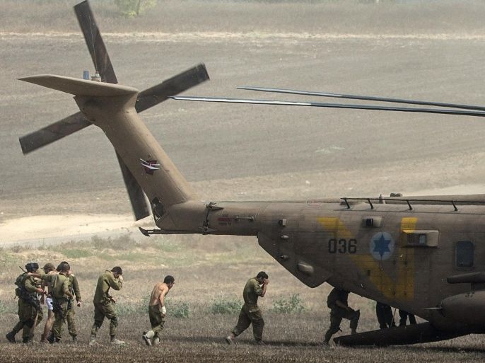 Injured Israeli soldiers board a helicopter as they are evacuated from Israel's border with the Gaza Strip on July 23, 2014, as the conflict entered its third week with neither side showing any sign of willingness to pull back. Israel's military pursued a relentless campaign of shelling and air strikes while the Palestinian militants hit back with rocket fire and fierce attacks on troops operating on the ground, killing 27 soldiers since the ground assault on Gaza began late on July 17. AFP PHOTO / JACK GUEZ