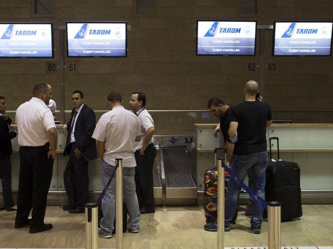 Passengers and airline staff stand near a check-in desk of an airline that cancelled its flight out of Tel Aviv at Ben Gurion International airport July 22, 2014. The Federal Aviation Administration (FAA) banned U.S. carriers from flying to or from Ben Gurion International Airport, after a rocket fired from Gaza struck near the airport's fringes, injuring two people. European airlines including Germany's Lufthansa, Air France and Dutch airline KLM said they were halting flights there too. Israel's flagship carrier El Al continued flights as usual. REUTERS/Siegfried Modola (ISRAEL - Tags: CONFLICT POLITICS CIVIL UNREST TRANSPORT)