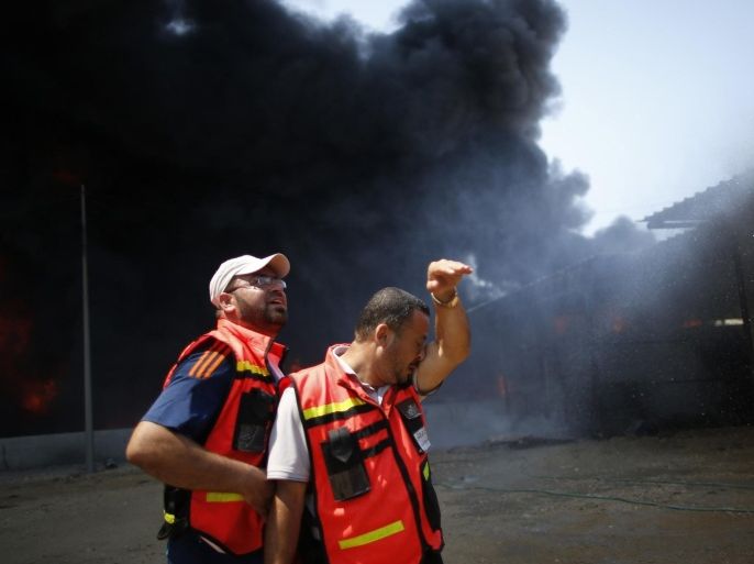 Palestinian firefighters participate in efforts to put out a fire at Gaza's main power plant, which witnesses said was hit in Israeli shelling, in the central Gaza Strip July 29, 2014. Israeli tank fire hit the fuel depot of the Gaza Strip's only power plant on Tuesday, witnesses said, cutting electricity to Gaza City and many other parts of the Palestinian enclave of 1.8 million people.An Israeli military spokeswoman had no immediate comment and said she was checking the report. Israel launched its Gaza offensive on July 8, saying its aim was to halt rocket attacks by Hamas and its allies. REUTERS/Mohammed Salem (GAZA - Tags: POLITICS CIVIL UNREST ENERGY)