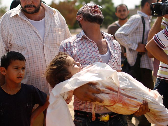 A relative cries as he carries the body of three-year-old Palestinian girl Haniyeh Abu Jarad, who medics said was killed along with her father and other six members from the same family by an Israeli tank shell, during their funeral in Beit Lahiya in the northern Gaza Strip July 19, 2014. Israeli forces on Saturday pressed ahead with a ground offensive in the Gaza Strip, where Palestinian militants kept firing rockets deep into Israel's heartland, pushing the death toll past 300 in almost two weeks of conflict. REUTERS/Suhaib Salem (GAZA - Tags: POLITICS CIVIL UNREST TPX IMAGES OF THE DAY) TEMPLATE OUT