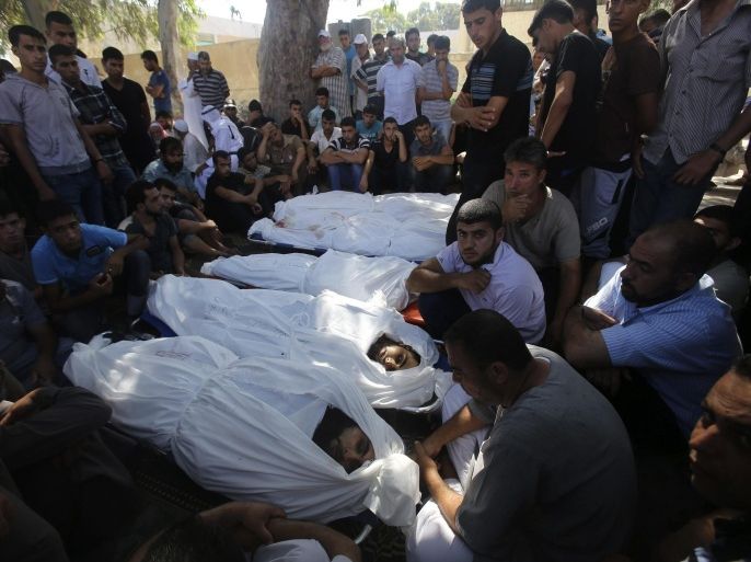 ATTENTION EDITORS - VISUAL COVERAGE OF SCENES OF INJURY OR DEATH People gather around the bodies of Palestinians from al-Astal family, whom medics said were killed in an Israeli air strike on their house, during their funeral in Khan Younis in the southern Gaza Strip July 30, 2014. Israeli fire killed at least 43 Palestinians in the Gaza Strip early on Wednesday as the Jewish state said it targeted Islamist militants at dozens of sites across the coastal enclave, while Egyptian mediators prepared a revised ceasefire proposal. Israel launched its offensive in response to rocket salvoes fired by Gaza's dominant Hamas Islamists and their allies. REUTERS/Ibraheem Abu Mustafa (GAZA - Tags: POLITICS CIVIL UNREST) TEMPLATE OUT