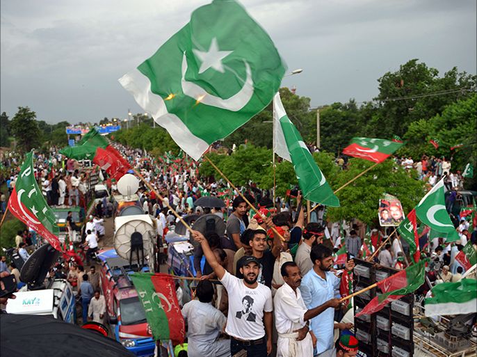 Islamabad, -, PAKISTAN : Pakistani supporters of cricketer-turned-politician Imran Khan wave flags as they gather during a protest rally against the country's Pakistan Muslim League-Nawaz-led government in Islamabad on August 16, 2014. Pakistani opposition figures ramped up calls for the fall of Prime Minister Nawaz Sharif's government on August 16 but failed to attract massive crowds of protesters promised at rallies in the capital. Addressing protesters he had led from the eastern city of Lahore, cricketer-turned-politician Imran Khan said he would stage a sit-in that would continue until Sharif leaves office, lashing out at the government he claims was elected fraudulently. AFP PHOTO / AAMIR QURESHI
