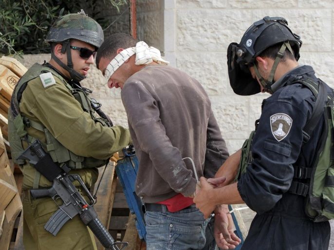 Members of the Israeli security forces arrest suspected Palestinians following the shooting of an Israeli police officer in an attack near the southern West Bank city of Hebron the previous week, as they conduct house raids in the village of Der Samet to find the culprits on April 24, 2014. The incident at the start of the Jewish Passover holiday was the first deadly attack on an Israeli in the occupied West Bank since the start of the year, and came as tensions were soaring over the near-breakdown of US-brokered peace talks. AFP PHOTO / HAZEM BADER