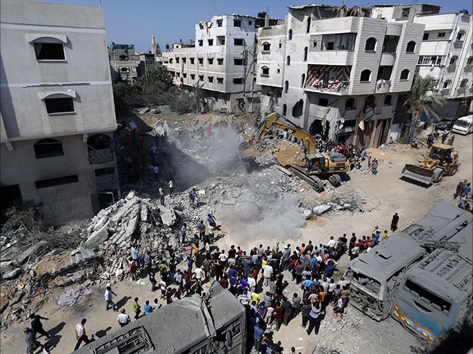 A digger removes on August 20, 2014, the cement and debris of a home destroyed the night before in an Israeli air strike on Gaza City's Sheikh Radwan neighbourhood which killed the wife and infant daughter of elusive Hamas military chief Mohammed Deif, the Islamist group said. Another 45 people were injured in the attack, they said. AFP PHOTO / MOHAMMED ABED