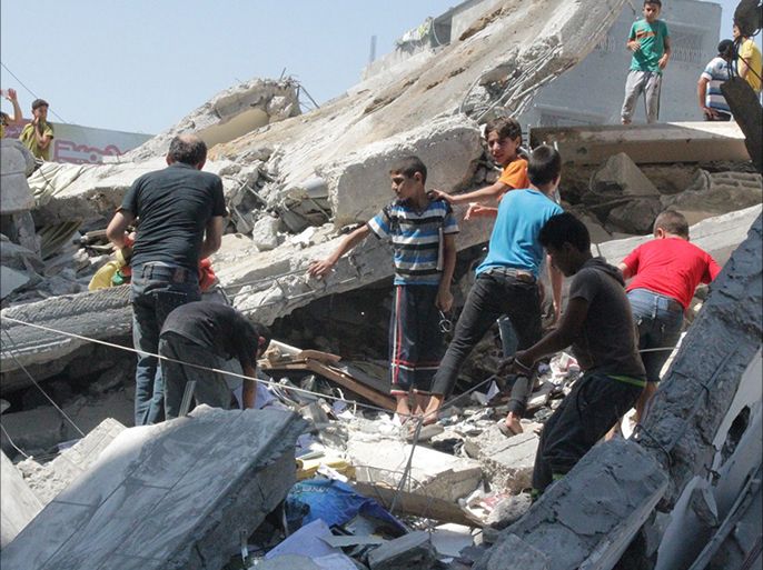 أطفال ينتشلون ما تبقى لهم من كتب من برج الباشا الذي دمرته اسرائيل في آخر ايام الحرب