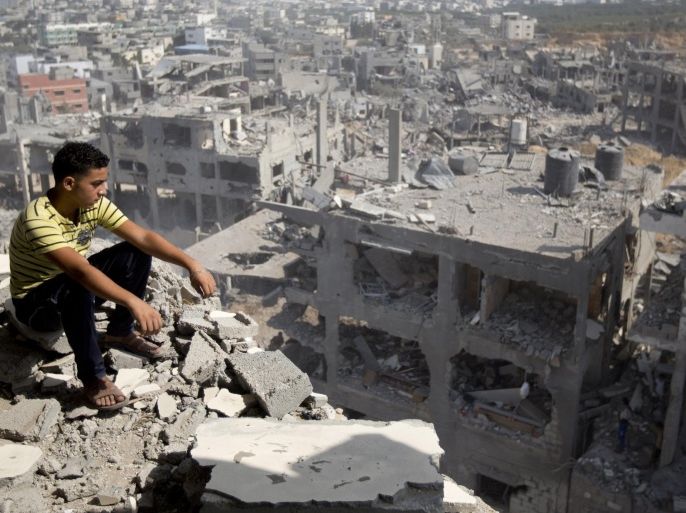 A Palestinian man looks out over destruction in part of Gaza City's al-Tufah neighbourhood as the fragile ceasefire in the Gaza Strip entered a second day on August 6, 2014 while Israeli and Palestinian delegations prepared for crunch talks in Cairo to try to extend the 72-hour truce. The ceasefire, which came into effect on August 5, has brought relief to both sides after one month of fighting killed 1,875 Palestinians and 67 people on the Israeli side. AFP PHOTO / MAHMUD HAMS