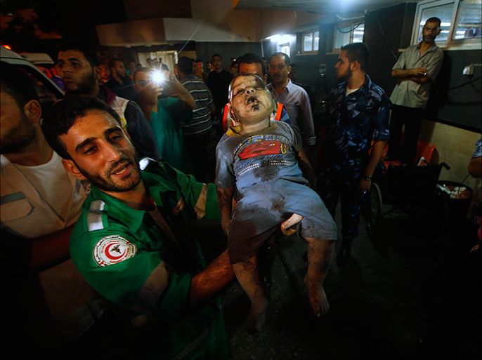 A medic carries the body of a two-year-old Palestinian girl, who hospital officials said was killed by an Israeli air strike, as he brings her body to a hospital in Gaza City August 19, 2014. The girl and a woman were killed in an Israeli air strike on