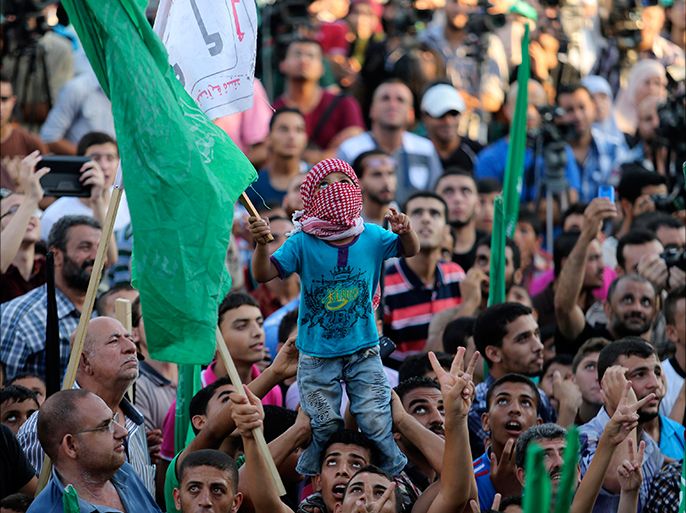 Palestinians Hamas supporters celebrate with people what they said was a victory over Israel, in Gaza City August 27, 2014. An open-ended ceasefire in the Gaza war held on Wednesday as Prime Minister Benjamin Netanyahu faced strong criticism in Israel over a costly conflict with Palestinian militants in which no clear victor emerged. REUTERS/Suhaib Salem (GAZA - Tags: POLITICS CIVIL UNREST CONFLICT)