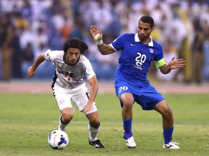 Saudi's Al-Hillal player Yasser al-Qahtani (R) fights for a ball against Qatar's Al-Sadd player Rodrigo Tabata (L) during their AFC Champions League football match on August 19, 2014, at the King Fahd International Stadium in Riyadh. AFP PHOTO /STR