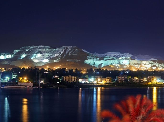 This Wednesday, April, 30, 2014 photo shows mountains illuminated by colorful lights on the west bank of the Nile River in Luxor, Egypt. on the east bank of the Nile River in Luxor, Egypt. Egyptian tourism officials, who Wednesday unveiled a replica of the tomb of King Tutankhamun in the desert valley where many of its ancient pharaohs were buried, are hoping the exhibit will help revive a tourism industry that has been heavily battered by the country's unrest since the 2011 uprising that toppled autocrat Hosni Mubarak. (AP Photo/Khalil Hamra)