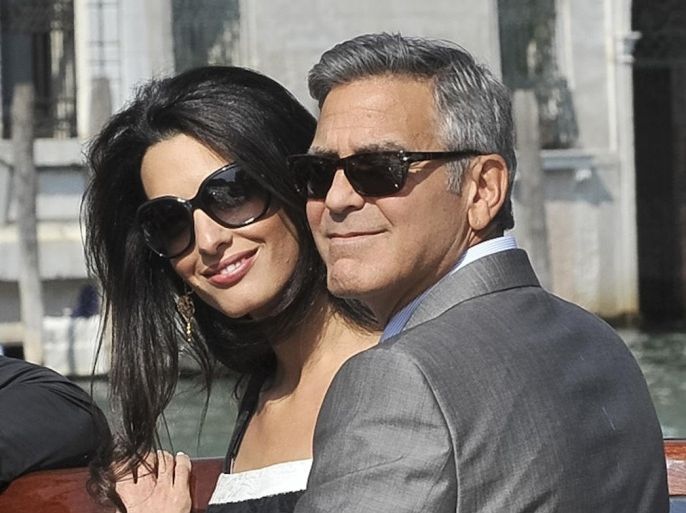 George Clooney and his fiancee Amal Alamuddin arrive in Venice, Italy, Friday, Sept. 26, 2014. Clooney, 53, and Alamuddin, 36, are expected to get married this weekend in Venice, one of the world's most romantic settings. (AP Photo/Luigi Costantini)