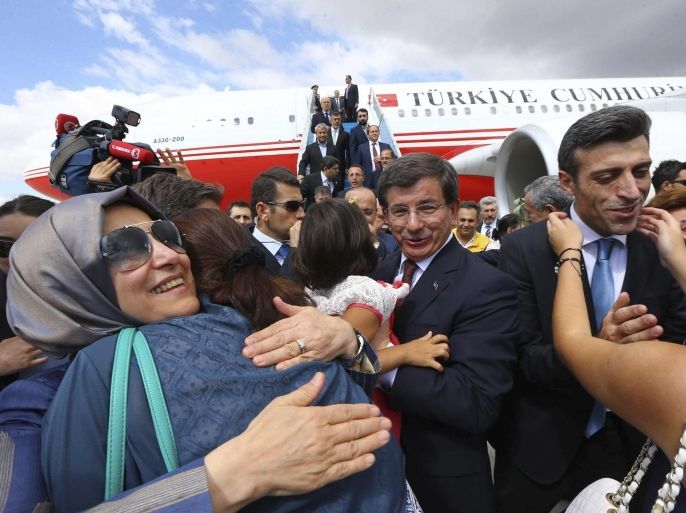 Turkish Consul General of Mosul Ozturk Yilmaz (2nd R) is welcomed by his relatives as Turkish Prime Minister Ahmet Davutoglu (C) looks on, as they arrive at Esenboga airport in Ankara September 20, 2014, in this handout courtesy of the Prime Minister's Press Office. Turkish intelligence agents brought 46 hostages seized by Islamic State militants in northern Iraq back to Turkey on Saturday after more than three months in captivity, in what President Tayyip Erdogan described as a covert rescue operation. Security sources told Reuters the hostages had been released overnight in the town of Tel Abyad on the Syrian side of the border with Turkey after being transferred from the eastern Syrian city of Raqqa, Islamic State's stronghold. The hostages, who included Yilmaz, diplomats' children and special forces soldiers, were seized from the Turkish consulate in Mosul on June 11 during a lightning advance by the Sunni insurgents. REUTERS/Hakan Goktepe/Prime Minister Press Office/Handout via Reuters (TURKEY - Tags: POLITICS CRIME LAW CIVIL UNREST TPX IMAGES OF THE DAY) ATTENTION EDITORS - THIS PICTURE WAS PROVIDED BY A THIRD PARTY. REUTERS IS UNABLE TO INDEPENDENTLY VERIFY THE AUTHENTICITY, CONTENT, LOCATION OR DATE OF THIS IMAGE. NO SALES. NO ARCHIVES. FOR EDITORIAL USE ONLY. NOT FOR SALE FOR MARKETING OR ADVERTISING CAMPAIGNS. THIS PICTURE IS DISTRIBUTED EXACTLY AS RECEIVED BY REUTERS, AS A SERVICE TO CLIENTS