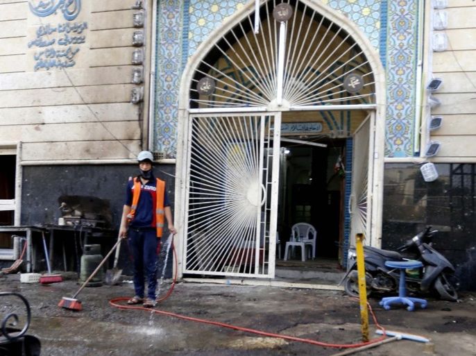 A municipal worker cleans the site of a car bomb attack in Baghdad, October 20, 2014. A suicide bomber killed 19 at a funeral in Baghdad on Sunday as an ambush halted Iraqi forces' advance on a key northern city controlled by Islamic State fighters. REUTERS/Thaier Al-Sudani (IRAQ - Tags: CRIME LAW POLITICS CONFLICT CIVIL UNREST)