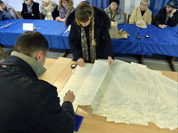Members of a district electoral commission stamp and count ballots as they prepare a polling station in the eastern Ukrainian city of Kramatorsk on October 25, 2014,