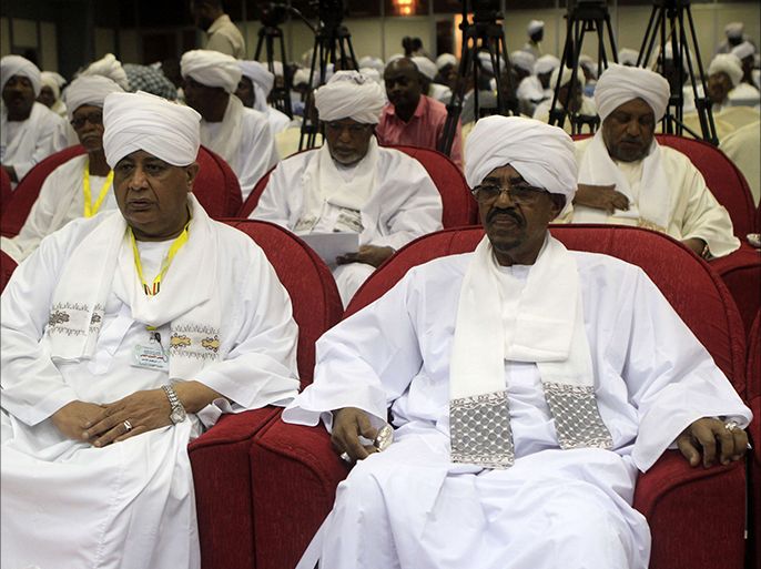 Sudan's President Omar al-Bashir (R) sits before addressing the National Consultative Council in the capital Khartoum on October 21, 2014. Sudan's ruling National Congress Party is to nominate three contenders to be its leader and presidential election candidate, with veteran incumbent Omar al-Bashir on th