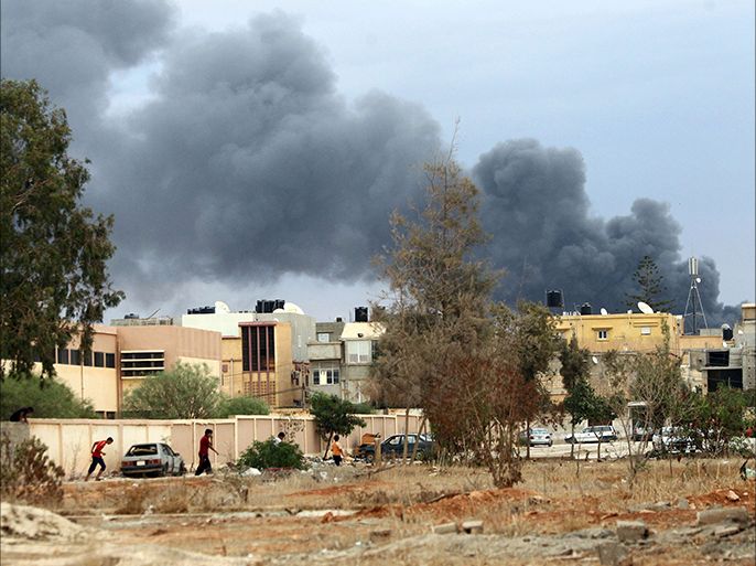 A picture taken on October 22, 2014 in the Libya's eastern coastal city of Benghazi shows smoke billowing from buildings after the Libyan airforce, loyal to former general Khalifa Haftar, pounded the buildings were reported to be used for storing ammunition belonging to Benghazi-based Islamist Ansar al-Sharia group. Fierce fighting have been raging for days in several parts of Libya's second city between pro-government forces led by Haftar and Islamist militias. AFP PHOTO / ABDULLAH DOMA