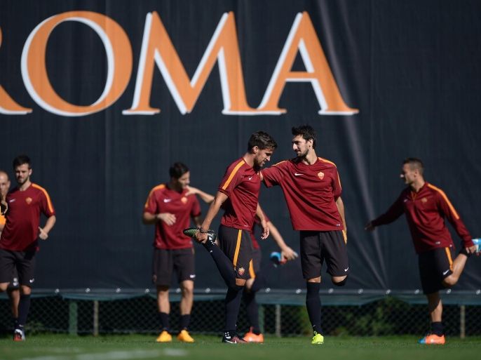 AS Roma Dutch midfielder Kevin Strootman (C) stretches with teamates during a training session a day before the Champion's League group stage football match AS Roma vs Bayern Munich on October 20, 2014 at the Trigoria training ground in the outskirts of Rome. AFP PHOTO / FILIPPO MONTEFORTE
