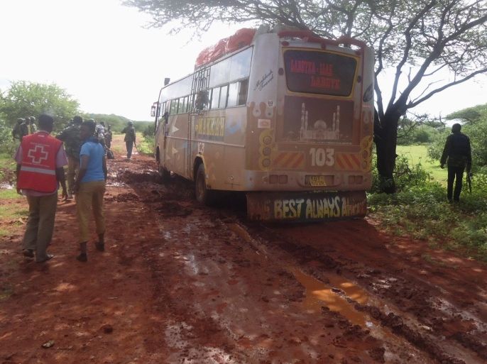 Rescue workers walk near a Nairobi-bound bus that was ambushed outside Mandera town, near Kenya's border with Somalia and Ethiopia, November 22, 2014. Somalia's al Shabaab insurgents said they were behind the bus attack in northeast Kenya that killed 28 people on Saturday, saying it was in retaliation for raids on mosques in the port city of Mombasa. Three of the group led out to be killed saved their lives by reciting verses of the Koran for the militants, a local security official said. REUTERS/Stringer (KENYA - Tags: SOCIETY CIVIL UNREST CRIME LAW)