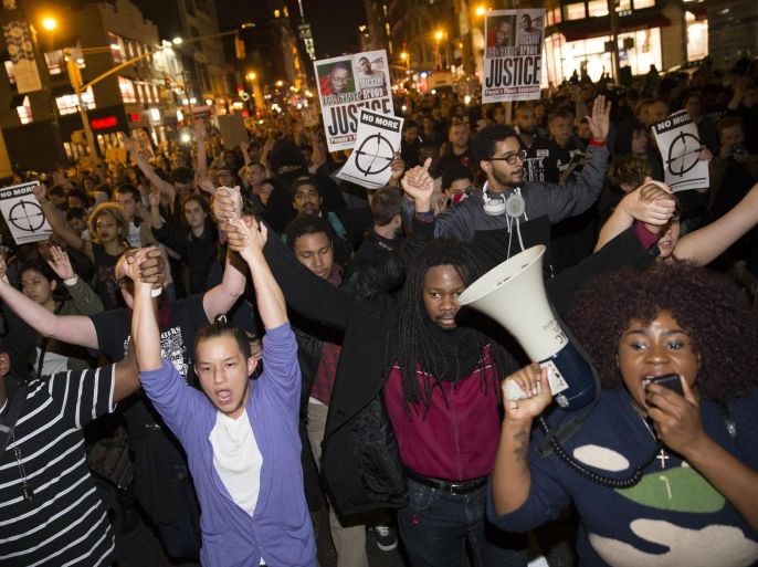 Protestors clasp hands as they march up Seventh Avenue towards Times Square after the announcement of the grand jury decision not to indict Ferguson police officer Darren Wilson in the fatal shooting of Michael Brown, an unarmed black 18-year-old, Monday, Nov. 24, 2014, in New York. (AP Photo/John Minchillo)