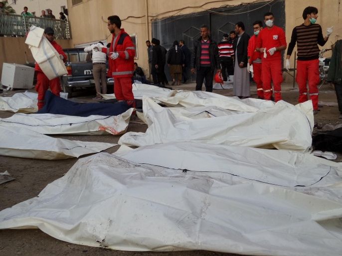 RAQQA, SYRIA - NOVEMBER 25: People place the bodies into body bags after the air strikes by Syrian army warplanes on the ISIL-held northern city of Raqqa, Syria on November 25, 2014. At least 130 people have been killed when Syrian war planes struck in Raqqa.