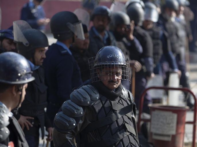 Pakistani police officers stand guard outside radical Red Mosque as supporters of Pakistani religious party Ahle Sunnat Wal-Jammat express solidarity with families of the students killed in Tuesday's attack on a military-run school in Peshawar, during a rally in Islamabad, Pakistan, Friday, Dec. 19, 2014. (AP Photo/B.K. Bangash)