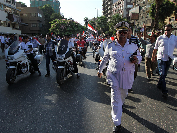 ‪قوات الشرطة تقوم بتأمين مسيرة مؤيدة للانقلاب فيما تفصل المعارضين له‬ (الجزيرة)