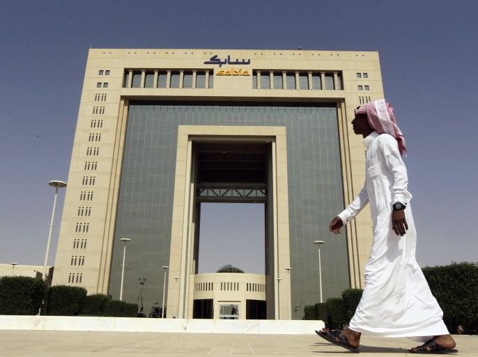 REFILE - CORRECTING BYLINEA man walks past the headquarters of Saudi Basic Industries Corp (SABIC) in Riyadh October 27, 2013. Higher sales helped SABIC post a rise in third-quarter net profit on Sunday, in line with analyst forecasts, as its chief executive officer Mohamed al-Mady said the outlook for next year was improving. REUTERS/Faisal Al Nasser (YEMEN - Tags: BUSINESS)