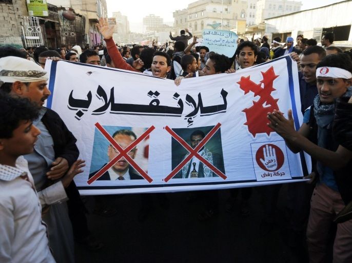 Protesters hold a banner showing crossed-out pictures of United Nations (U.N.) special envoy to Yemen Jamal Benomar (L) and the leader of Yemen's Houthis Abdel-Malek al-Houthi, during a demonstration against the Houthi movement in Sanaa January 28, 2015. Houthi, leader of the Houthis who control the capital Sanaa, said on Tuesday his group was seeking a peaceful transfer of power after the resignation of Yemeni President Abd-Rabbu Mansour Hadi, and urged all factions to work together to solve the crisis. The banner reads: "No to the coup!" REUTERS/Khaled Abdullah (YEMEN - Tags: POLITICS CIVIL UNREST)