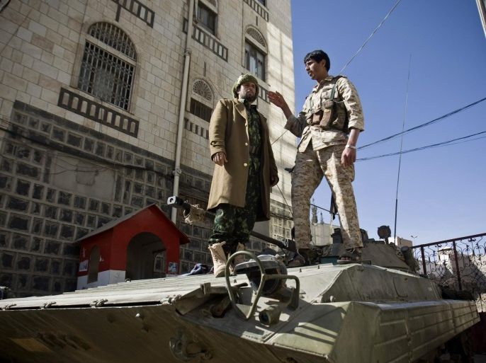 Houthi Shiite Yemeni wearing army uniforms stand atop an armored vehicle, which was seized from the army during recent clashes, outside the house of Yemen's President Abed Rabbo Mansour Hadi in Sanaa, Yemen, Thursday, Jan. 22, 2015. Heavily armed Shiite rebels remain stationed outside the Yemeni president's house and the palace in Sanaa, despite a deal calling for their immediate withdrawal to end a violent standoff. (AP Photo/Hani Mohammed)
