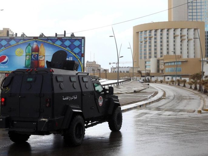 Libyan security forces and emergency services surround Tripoli's central Corinthia Hotel (R) on January 27, 2015 in the Libyan capital. The hotel was reportedly attacked by Islamist gunmen today and gunfire was heard, an AFP photographer reported. According to security sources at the scene, four armed men had detonated a car bomb in front of the Corinthia Hotel, which is popular with foreigners, killing a guard, before rushing into the hotel. AFP PHOTO/MAHMUD TURKIA