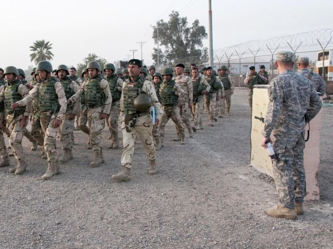 In this Thursday, Feb. 13, 2015 photo released by the U.S. Army, U.S. Army soldiers from the 1st Infantry Division, based at Fort Riley, Kansas, watch as Iraqi army soldiers with the 72nd Brigade march at Camp Taji, north of Baghdad, Iraq. More than 1,400 members of the 72nd Brigade graduated from a six-week training course, assisted by U.S. Soldiers as part of helping combat the Islamic State militant group in Iraq. Iraq's Prime Minister Haider al-Abadi has called on the U.S. and other coalition nations to ramp up support for his country's beleaguered military. (AP Photo/Staff Sgt. Daniel Stoutamire, U.S. Army 1st Infantry Division)