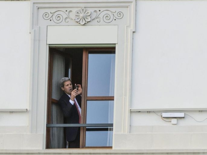 US Secretary of State John Kerry takes a picture with his smartphone from a window of the hotel during a break after a bilateral meeting with Iranian Foreign Minister Mohammad Javad Zarif (not pictured) for a new round of Nuclear Iran Talks, in Lausanne, Switzerland, 27 March 2015.