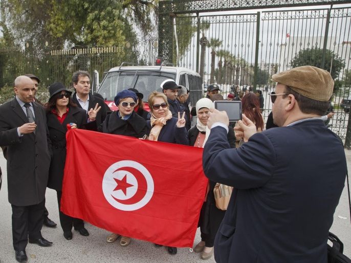 A group of Tunisian writers pose for a group picture at the entrance gate of the National Bardo museum to show solidarity for the victims of last Wednesday attack in Tunis, Tunisia, Saturday March 21, 2015. The two extremist gunmen who killed 21 people at a museum in Tunis trained in neighboring Libya before caring out the deadly attack, a top Tunisian security official said. (AP Photo/Michel Euler)