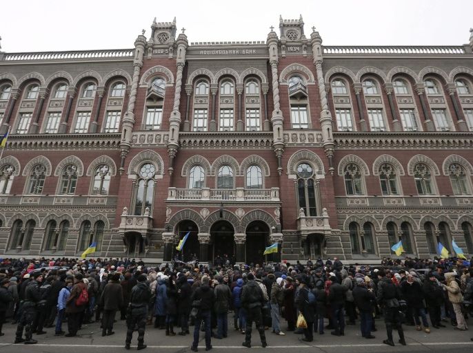 People attend a rally against the financial policy of the Ukrainian National Bank in front of the Ukrainian National Bank building in downtown Kiev, Ukraine, 24 February 2015. Ukraine's central bank introduced new capital controls in an attempt to stem a collapse of the country's currency, which has lost more than half of its value since the crisis that erupted in early 2014. Foreign ministers of Russia, Ukraine, France and Germany made a fresh call for a 'strict implementation' of the ceasefire agreement in eastern Ukraine and suggested expanding an international observer mission there.
