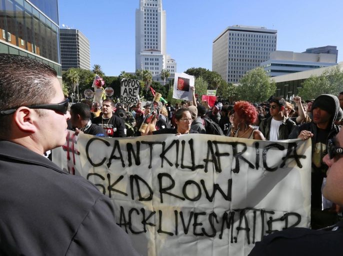 Protestors carry a banner during a rally in front of the police administration building in downtown Los Angeles on Tuesday, March 3, 2015. Several dozen people rallied in protest of the shooting, which came amid lingering tensions in the U.S. over the police killings of unarmed black men in Missouri and New York City. (AP Photo/Nick Ut)