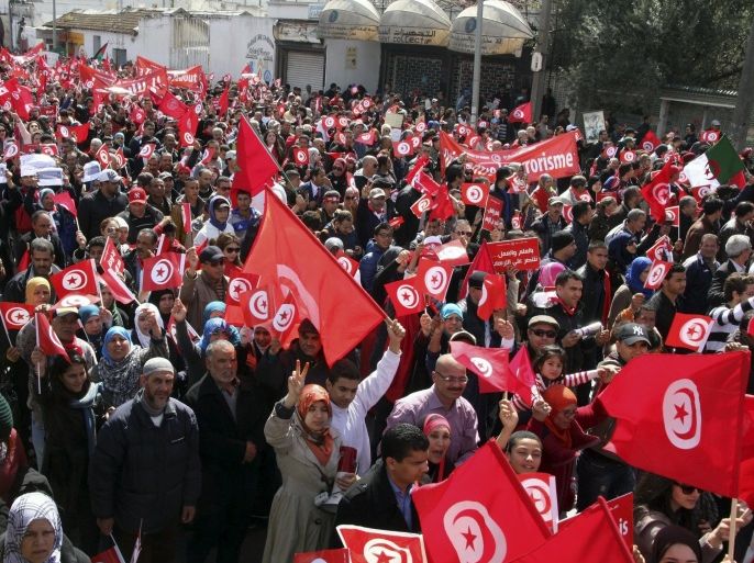 Tunisians wave their national flags during a march against extremism outside Tunis' Bardo Museum, March 29, 2015. World leaders joined tens of thousands of Tunisians on Sunday to march in solidarity against Islamist militants, a day after security forces killed members of a group blamed for a deadly museum attack. REUTERS/Stringer
