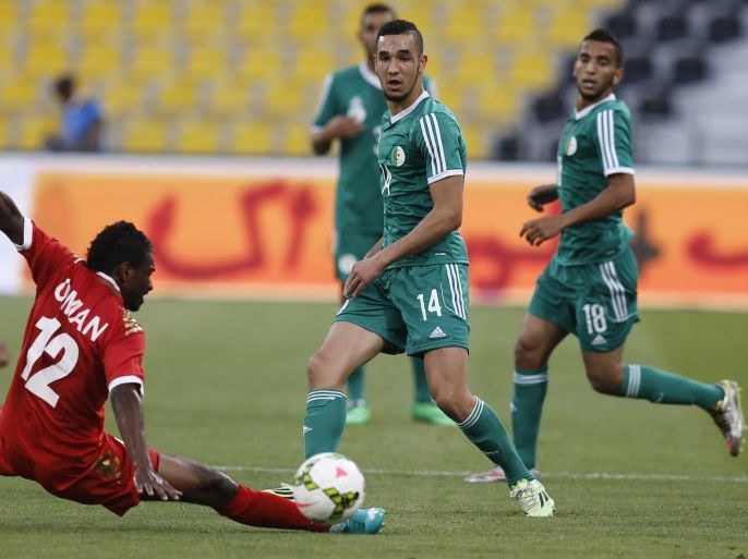 Oman's Ahmed Mubarak (L) defends a shot on goal by Algeria's Nabil Bentaleb (C) during their friendly football game on March 30, 2015 at the Qatar Club Stadium in Doha, as part of the preparations for the second round of the 2018 World Cup's Asian leg qualifiers. AFP PHOTO / KARIM JAAFAR / AL-WATAN DOHA == QATAR OUT ===