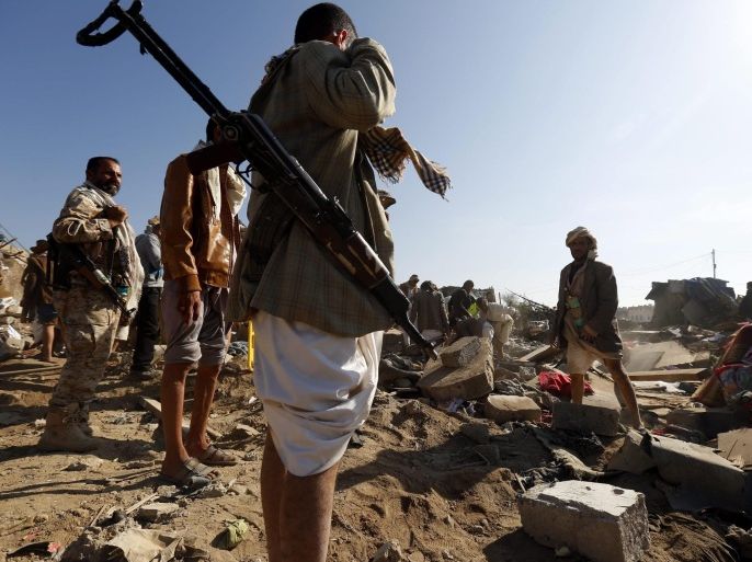 Armed members of Houthi militias (L) keep watch as people search for survivors under the rubble of houses that allegedly were destroyed by a Saudi air strike, in Sana'a, Yemen 26 March 2015. Saudi Arabia and other Gulf states launched air strikes against Houthi rebels which have taken over large parts of Yemen, attacking the Sana'a military Airport and Jiraf area, a Houthi stronghold. The strikes were 'in support of the people of Yemen and their legitimate government,' Saudi Arabia's Washington ambassador Adel al-Jubeir said. The military operation by a 'coalition of over 10 countries' was in response to an appeal from embattled Yemeni President Abdo Rabbo Mansour Hadi, al-Jubeir said.